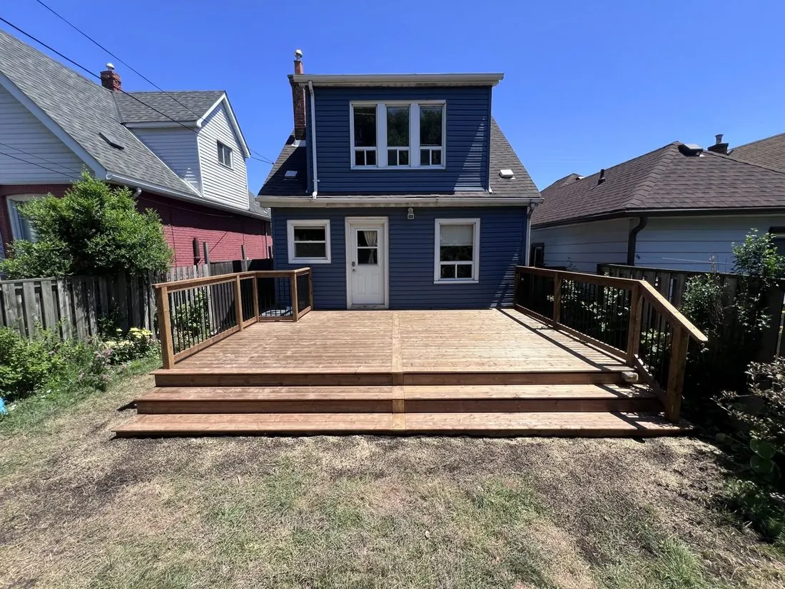 Recent Northern Deck project: fresh pressure-treated deck with wide stairs and black metal railings